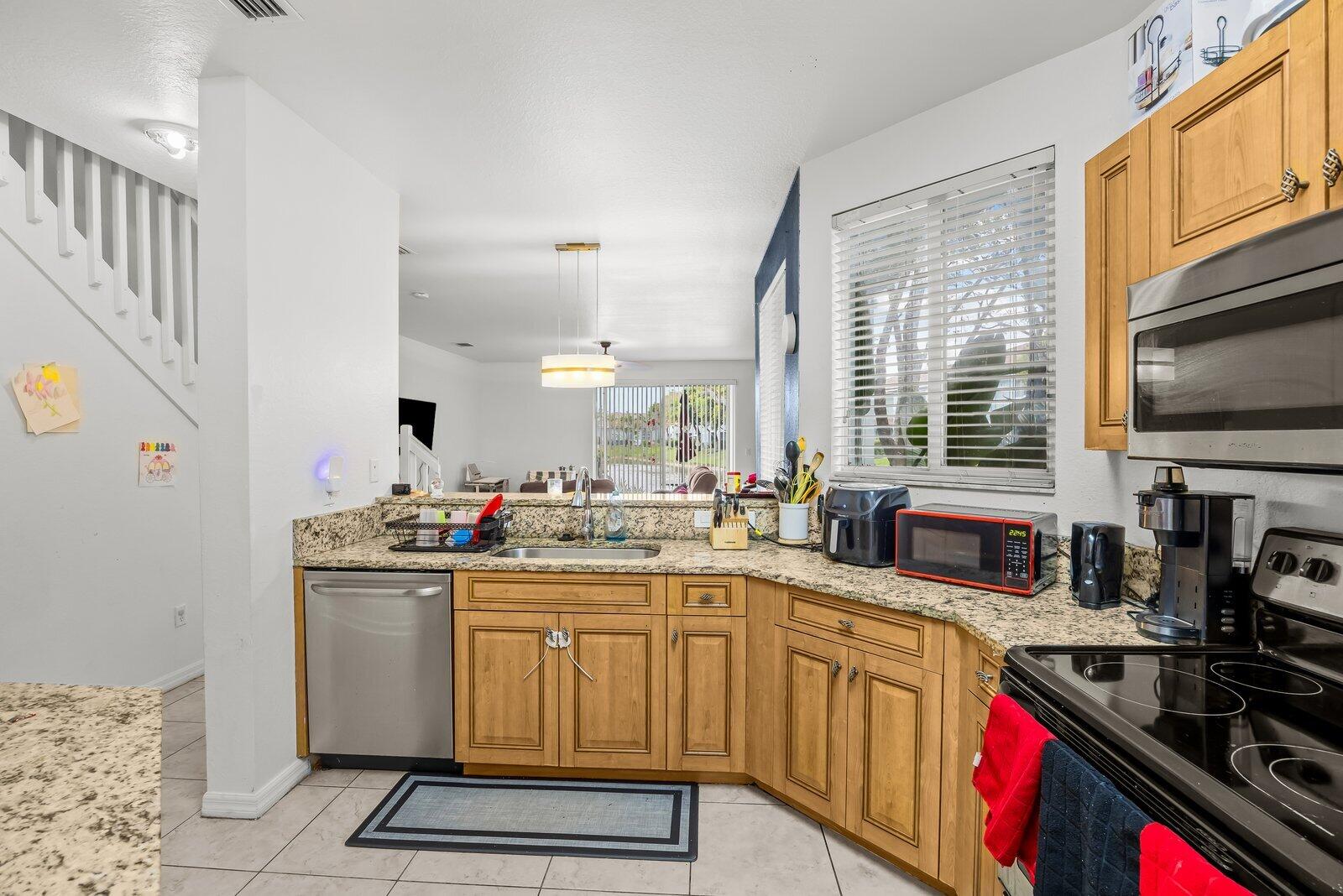 1955 Alamanda Way Riviera Beach, FL 33404 - Photo 6 of 25 a kitchen with a sink stove and cabinets
