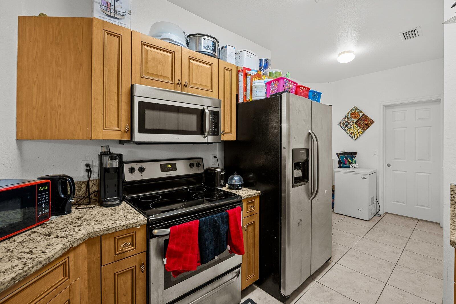 1955 Alamanda Way Riviera Beach, FL 33404 - Photo 8 of 25 a kitchen with stainless steel appliances granite countertop a refrigerator stove and sink