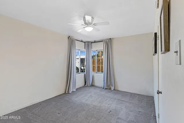 an empty room with closet and a ceiling fan