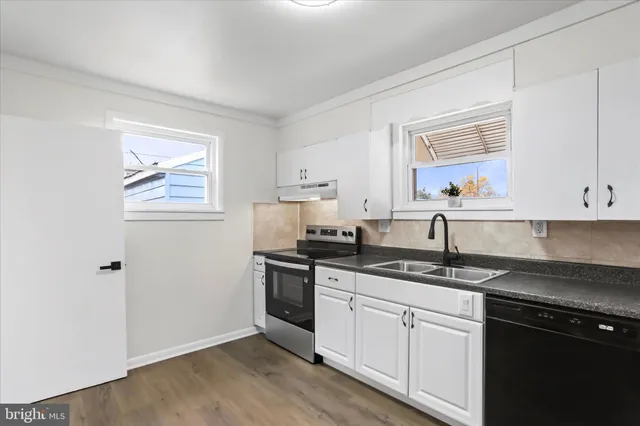 a kitchen with granite countertop cabinets stainless steel appliances a sink and a window