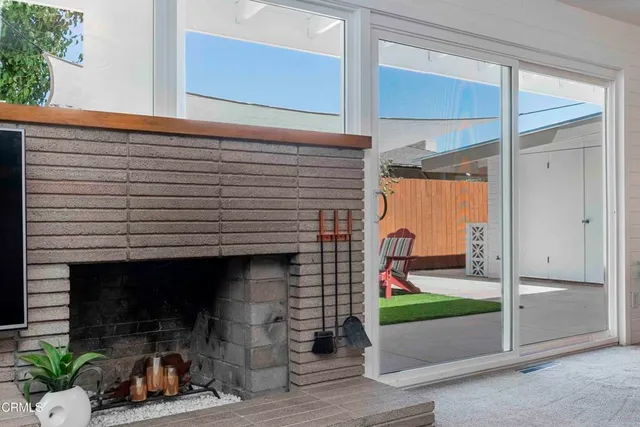 a living room with furniture a fireplace and a large window