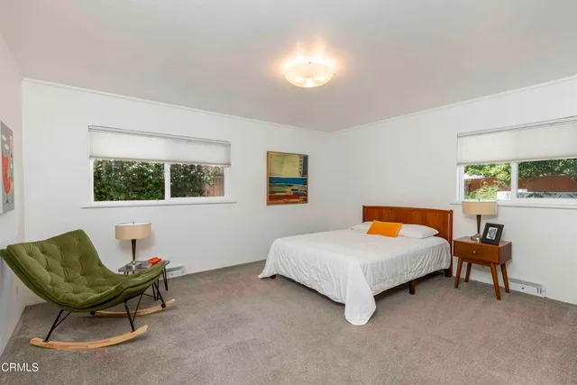 a view of a patio with couches table and chairs under an umbrella