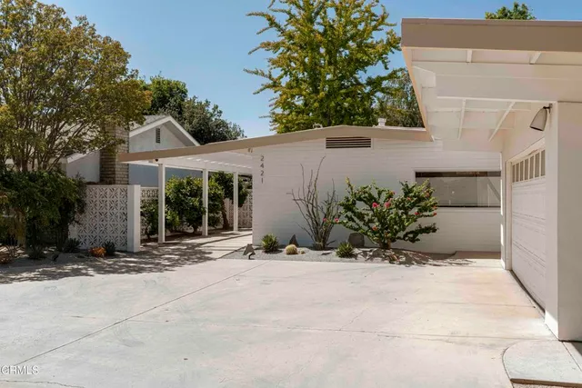 a vase of flowers sitting on a floor in front of a door