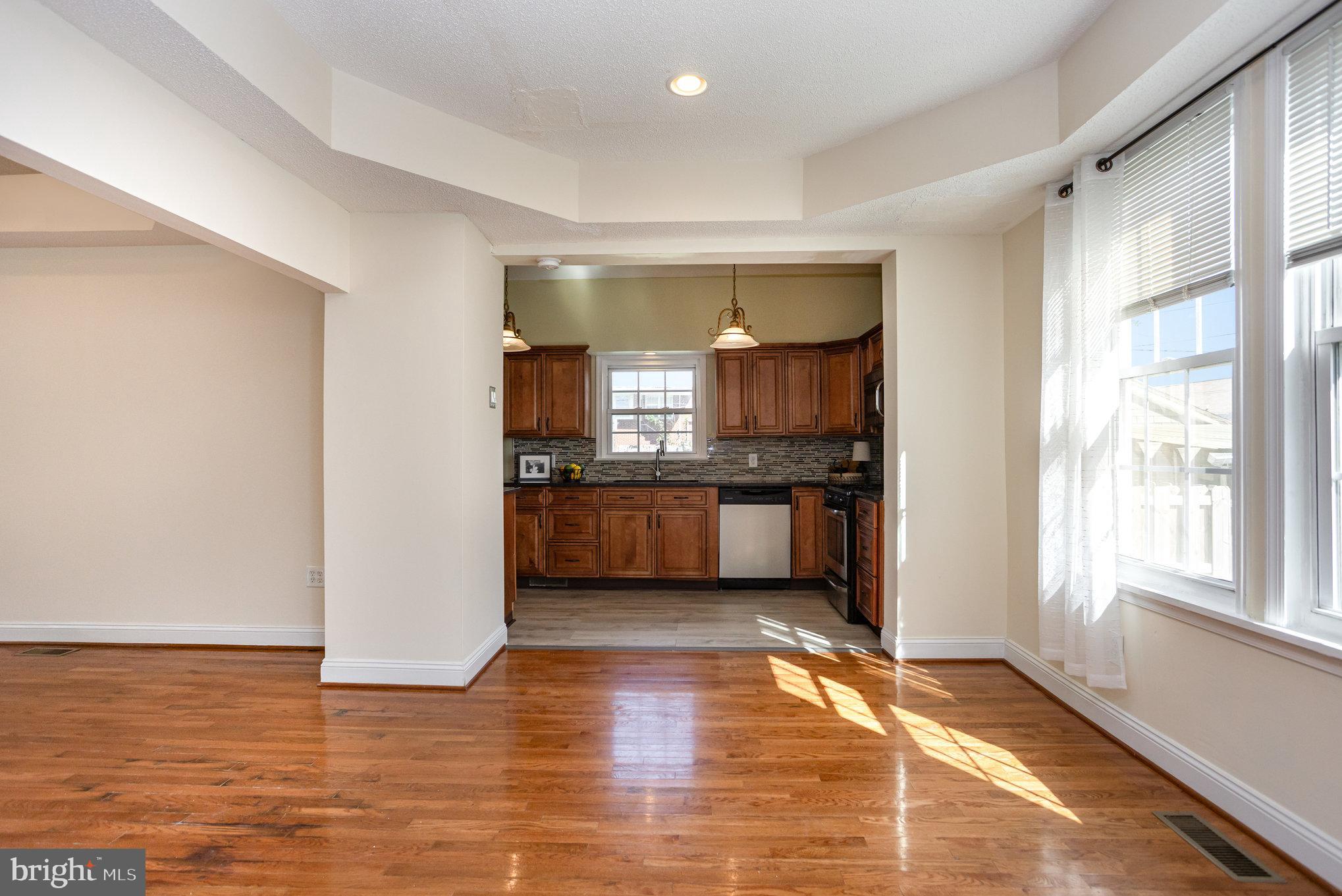 505 47th Street Baltimore, MD 21224 - Photo 17 of 41 a view of a kitchen with kitchen island wooden floors stainless steel appliances and windows