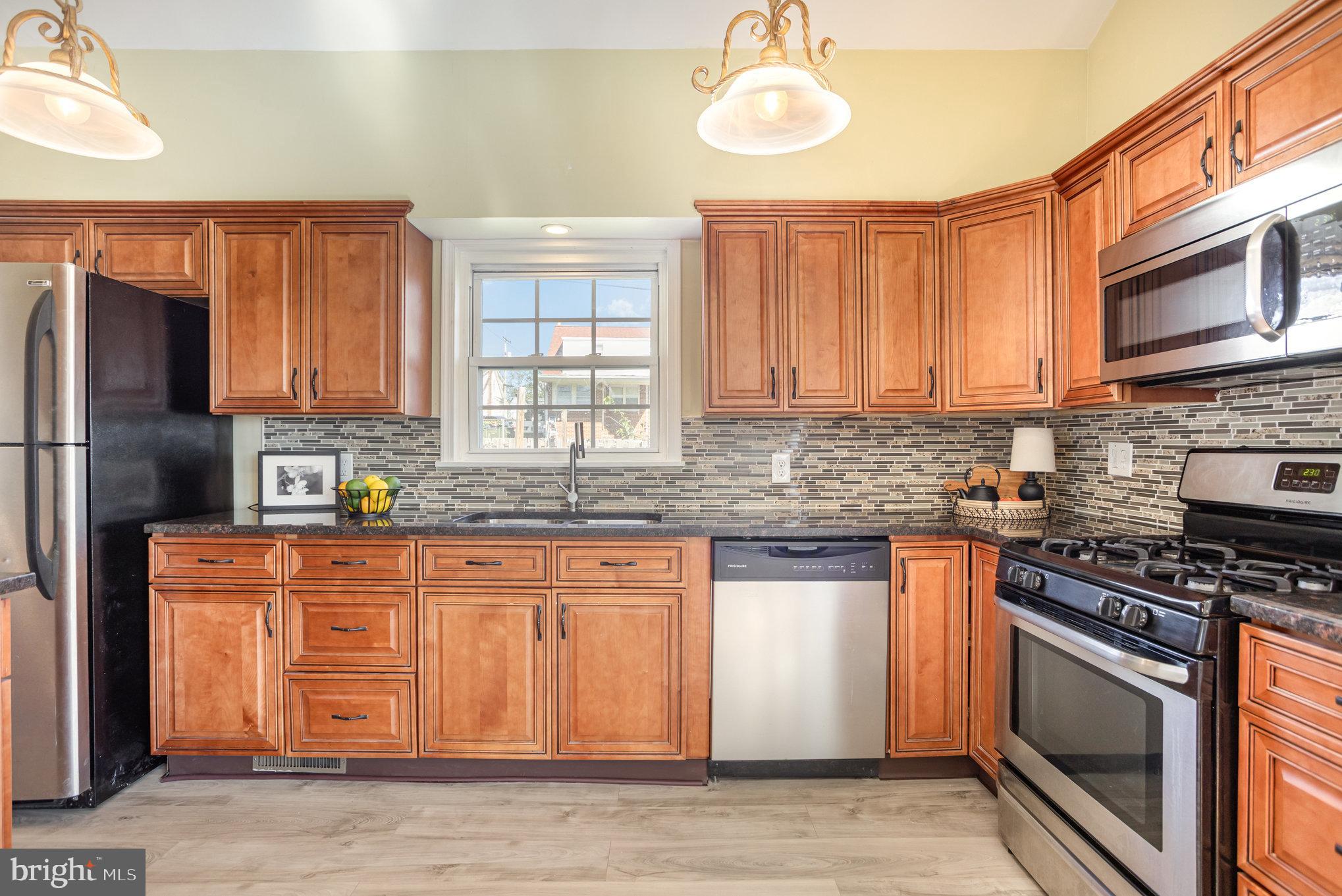 505 47th Street Baltimore, MD 21224 - Photo 19 of 41 a kitchen with stainless steel appliances granite countertop a stove a sink and a microwave
