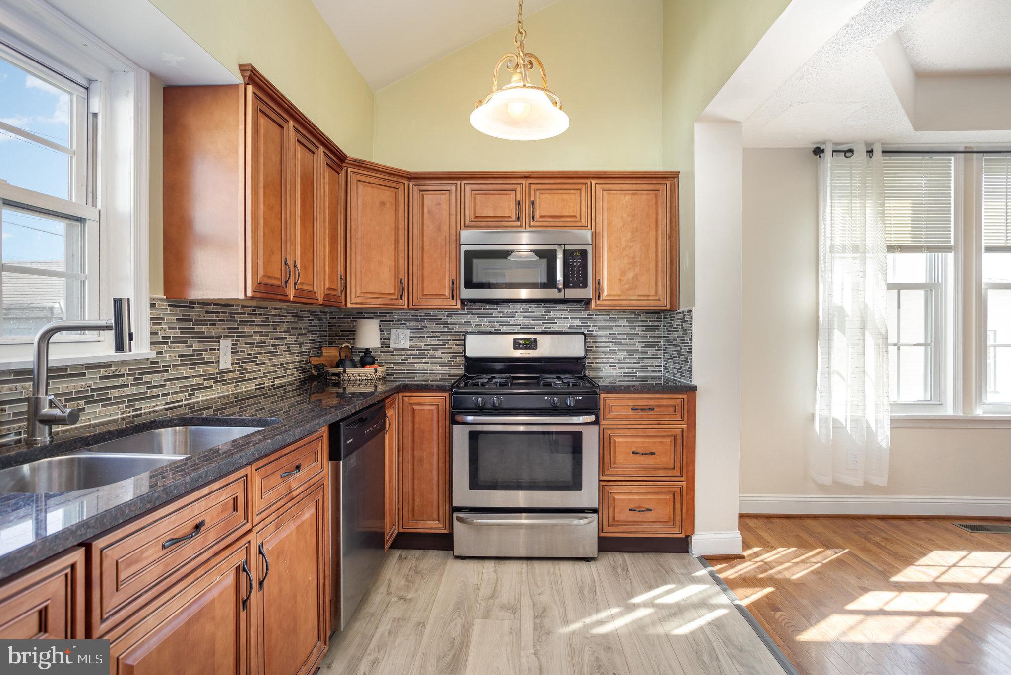 505 47th Street Baltimore, MD 21224 - Photo 21 of 41 a kitchen with stainless steel appliances granite countertop a stove a sink and a microwave