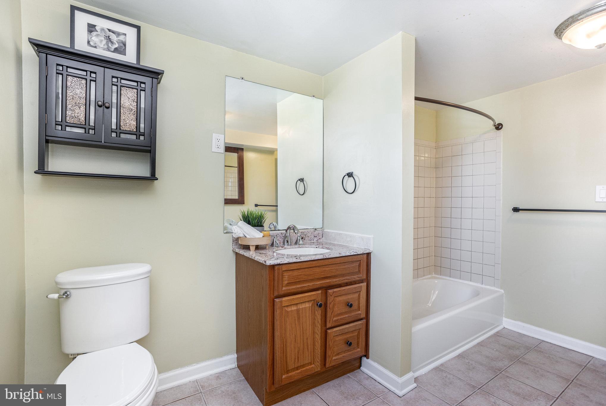 505 47th Street Baltimore, MD 21224 - Photo 29 of 41 a bathroom with a granite countertop toilet a sink and bathtub