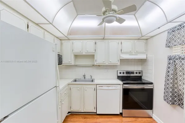 a kitchen with stainless steel appliances a stove a refrigerator and white cabinets