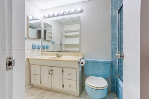 a bathroom with a granite countertop toilet sink and mirror