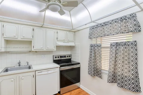 a kitchen with stainless steel appliances granite countertop a sink a stove and cabinets
