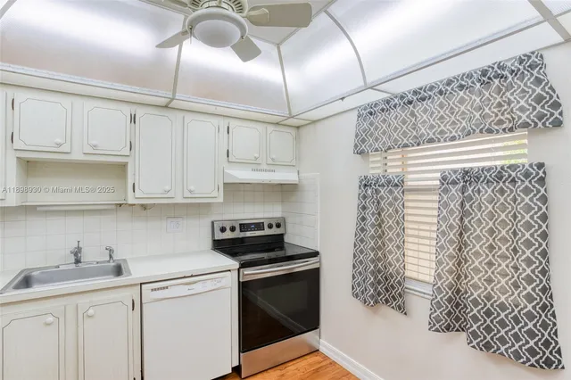 a kitchen with stainless steel appliances granite countertop a sink a stove and cabinets