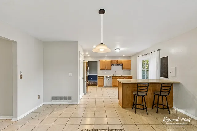 a view of a dining room and livingroom with furniture wooden floor a chandelier
