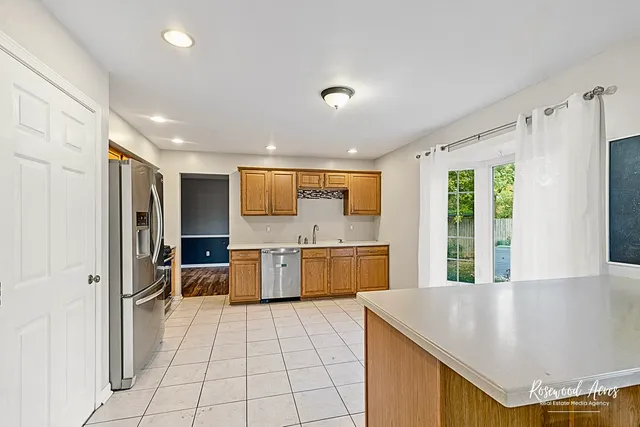 a large kitchen with a large window and stainless steel appliances