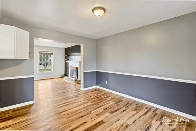 a view of kitchen and empty room with wooden floor