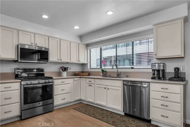 a kitchen with a sink stove cabinets and window