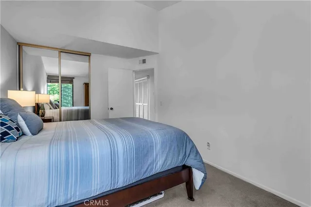 a bedroom with a bed and large window