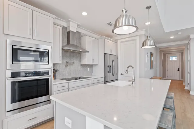 a large kitchen with kitchen island a stove a sink a refrigerator and cabinets