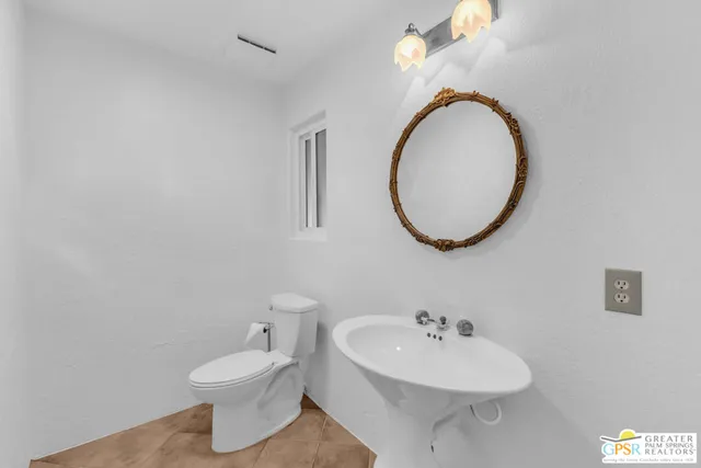 a bathroom with a sink a mirror and a toilet