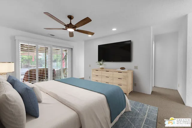 a bedroom with a bed and a flat screen tv