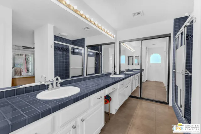 a spacious bathroom with a granite countertop double vanity sink and a mirror