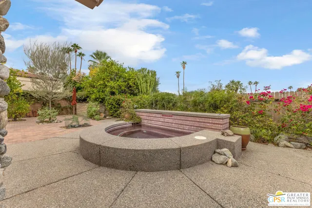 a swimming pool with outdoor seating and yard in the back