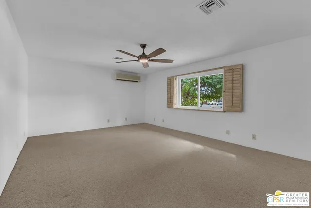 an empty room with windows and ceiling fan