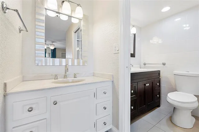 a bathroom with a toilet a sink a vanity and mirror