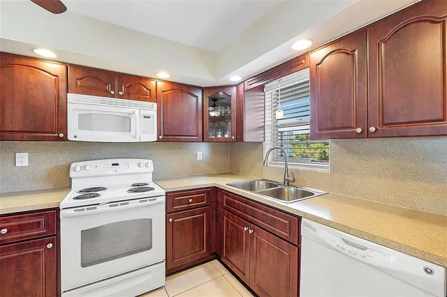 a kitchen with stainless steel appliances granite countertop wooden cabinets a stove a sink and dishwasher