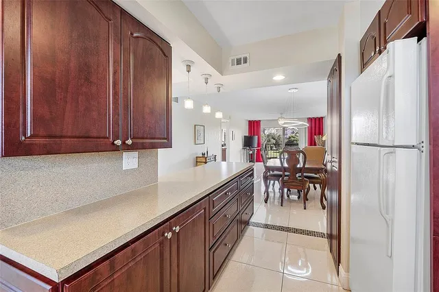 a kitchen with granite countertop a refrigerator a sink and a stove