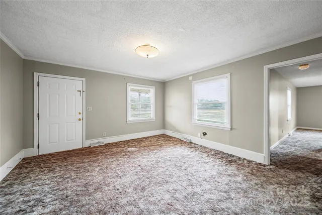 a view of empty room with window and wooden floor