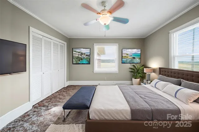 a bedroom with a balcony a bed and a chandelier