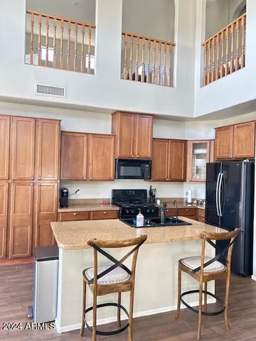 a kitchen with stainless steel appliances granite countertop a stove top oven a dining table and chairs