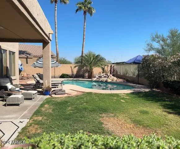 a view of a swimming pool with a chair and tables in the patio