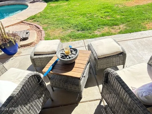 a view of a patio with lawn chairs next to a yard