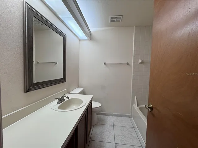a bathroom with a sink and mirror with toilet