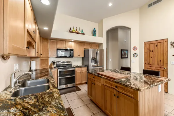 a kitchen with stainless steel appliances granite countertop a stove top oven a sink dishwasher and cabinets with wooden floor