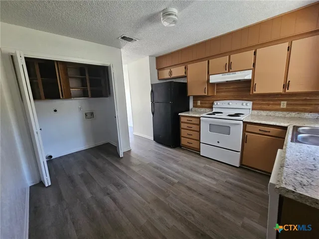 a kitchen with stainless steel appliances granite countertop a stove a sink and a refrigerator