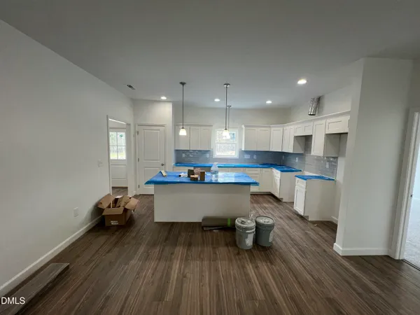 a kitchen with wooden floors cabinets and entryway
