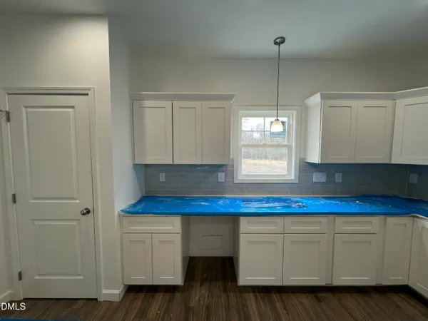 a kitchen with cabinets appliances and wooden floor
