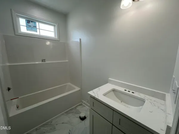 a view of cabinets and utility room with window