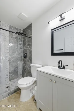 a bathroom with a sink a toilet and a mirror