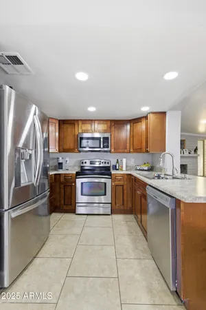 a large kitchen with a large counter top stainless steel appliances and cabinets