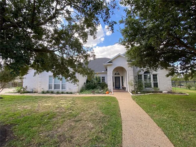 a front view of a house with a garden and yard