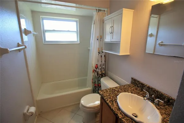 a bathroom with a granite countertop sink toilet mirror and shower