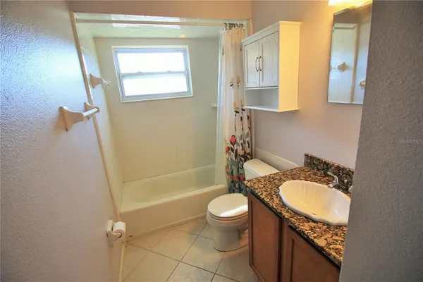 an empty room with a window and ceiling fan