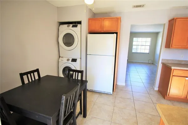 a view of a kitchen with refrigerator and window
