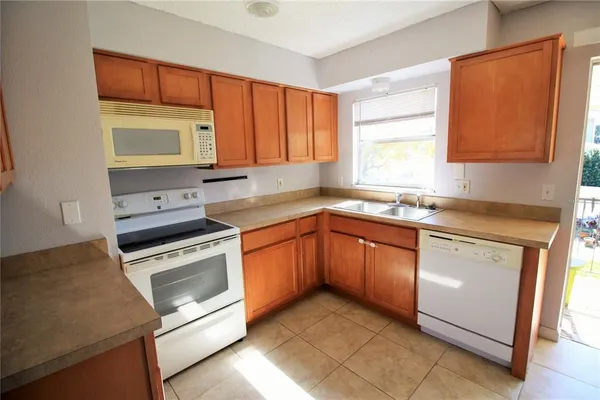 a kitchen with granite countertop cabinets stainless steel appliances a sink and a window