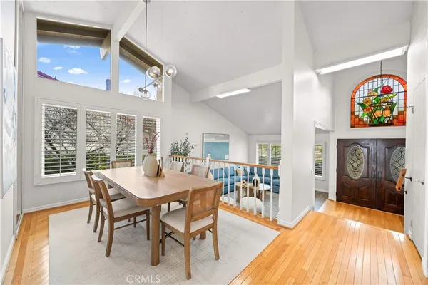 a view of a dining room with furniture a chandelier and wooden floor