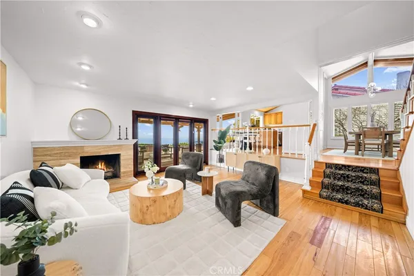 a living room with furniture a fireplace and a floor to ceiling window