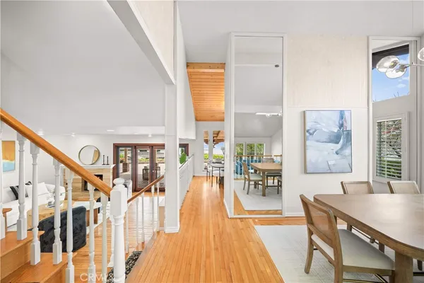 a dining room with wooden floor and windows